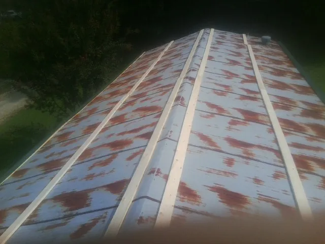 Rusted metal roof panels with new wood purlins before replacement — Storm Damage Roof Repair in Winston-Salem by Roofing Brothers