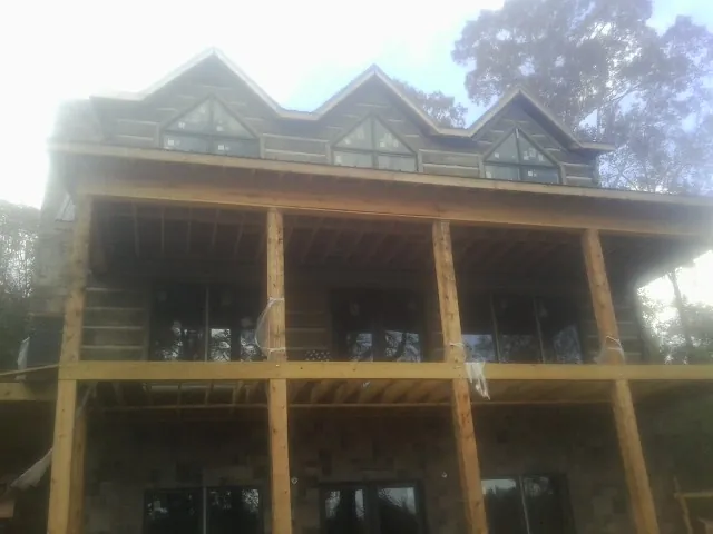 Dormers and porch framing on a large log home under construction — Roof Coating work by our crew in Winston-Salem