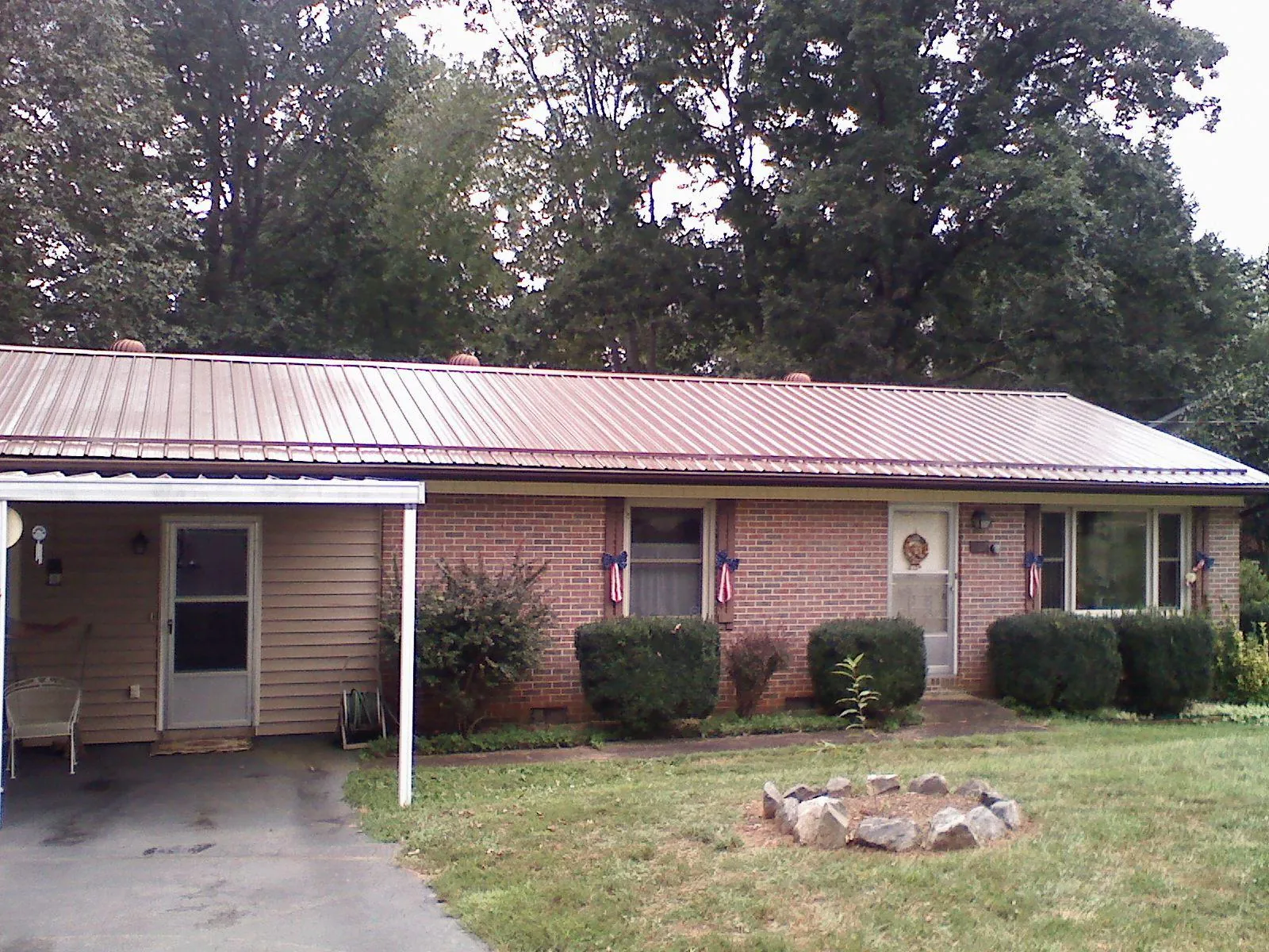 Bronze metal roof and carport on a brick ranch home — Roof Repair work by our crew in Winston-Salem