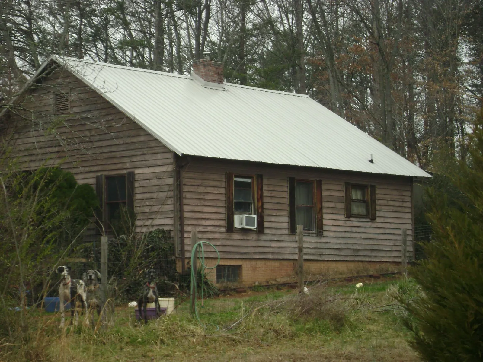 White metal roof on an old wood sided farmhouse, from a Asphalt Shingle Roof Repair job in Winston-Salem
